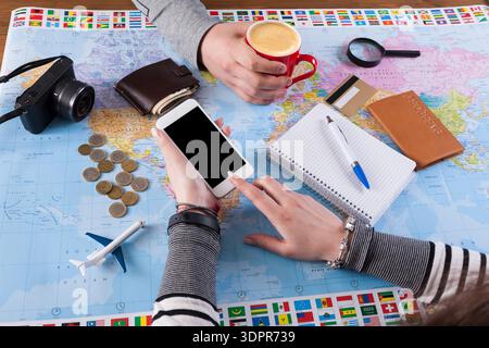 Planning a Trip With Coffee, Maps, and a Smartphone at a Table Stock Photo