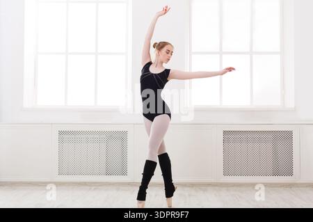 Ballerina Practicing Dance Moves in a Studio With Large Windows and Wooden Floor Stock Photo