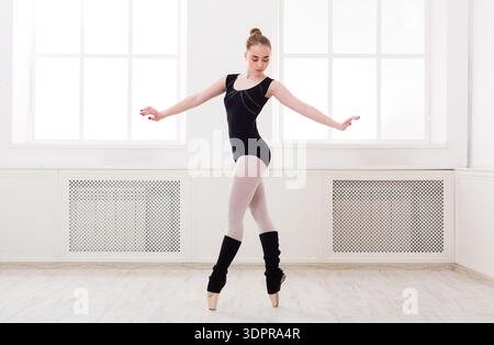 Young Dancer Practices Ballet in a Bright Studio With Large Windows During Daylight Hours Stock Photo