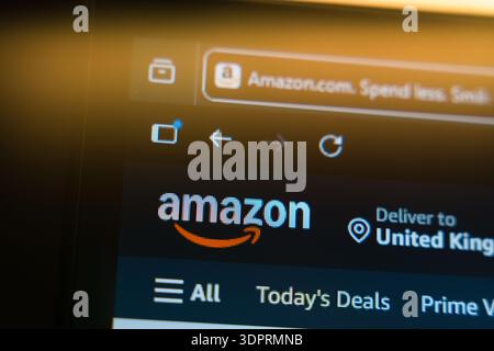 Amazon homepage displayed on a computer screen with the official logo and browser tab in a warm golden light, representing global e-commerce, online s Stock Photo