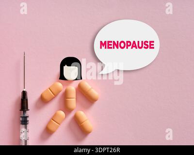 Woman figure made from pills and a head icon, with a syringe and a speech bubble with MENOPAUSE text Stock Photo