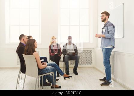 Group Learning Session in a Bright Classroom With a Student Presenting to Peers Stock Photo