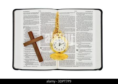 Pocket watch and cross on a open Holy Bible with a white background. Stock Photo