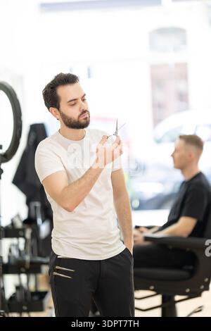 Barber preparing scissors for client grooming service Stock Photo