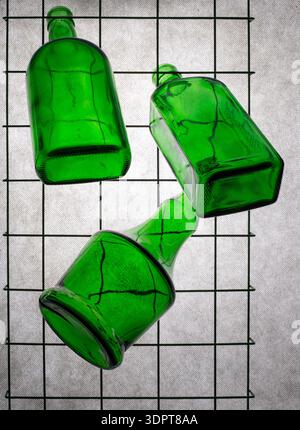 Three green empty bottles on a gray background Stock Photo