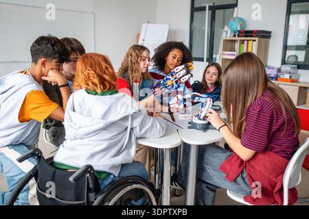 Teen students working as a team on robotics project in classroom. Stock Photo
