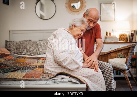 Elderly spouses sharing quiet moment before sleep. Stock Photo