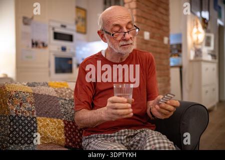 Senior man taking prescribed pills before going to sleep. Stock Photo