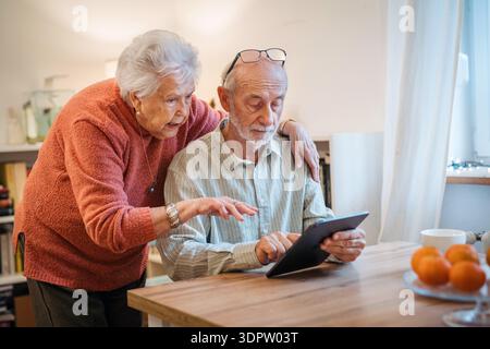 Senior coule working with tablet, having problem with technology. Stock Photo