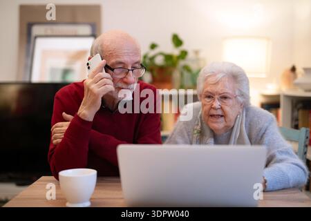 Old people having problem with laptop, calling for help. Stock Photo