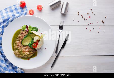 Grilled Chicken With Sauce and Vegetables on a Plate With Table Setting and Spices Stock Photo