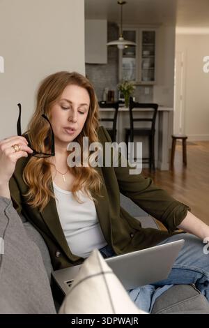Thoughtful woman in her 40s working remotely Stock Photo
