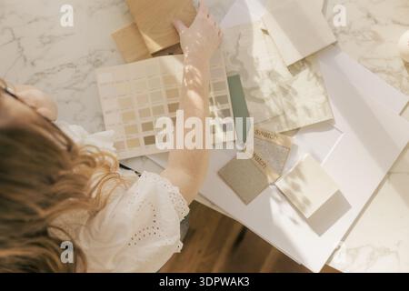 Designer selecting neutral fabric swatch in sunlight Stock Photo