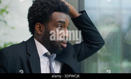 Close up stressed anxiety worried depressed African American business man thinking problem solution looking at window in office trouble pondering Stock Photo