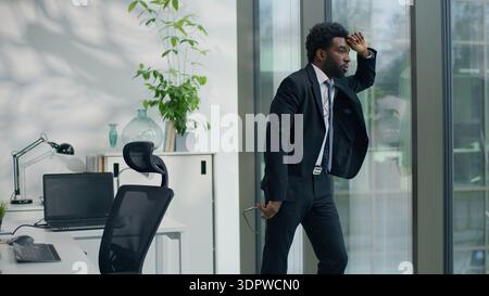Pensive African American business man stressed worried anxiety thinking in office looking to window gazing create solution bad trouble think ethnic Stock Photo