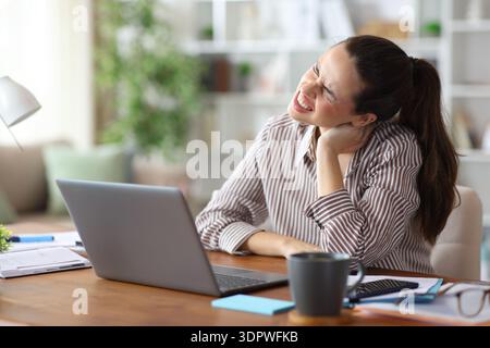 Freelancer suffering neck ache while working complaining at home Stock Photo