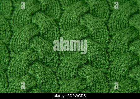 Green Cable Knit Fabric woolen sweater background. Knitwear woolen textile Stock Photo