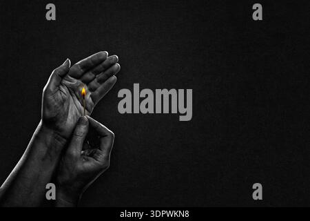 Hand Holding and Protecting Lit Match in Black and White on Textured Paper Background, Copy Space Stock Photo