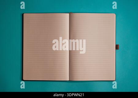Open lined notebook on teal background, minimalist stationery mockup top view Stock Photo
