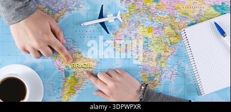 Top view of couple pointing at Brazil on world map Stock Photo