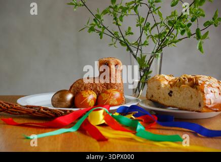 Traditional Czech Easter still life with sweet bread mazanec, Easter lamb cake, painted eggs, braided willow whip and fresh green branches Stock Photo