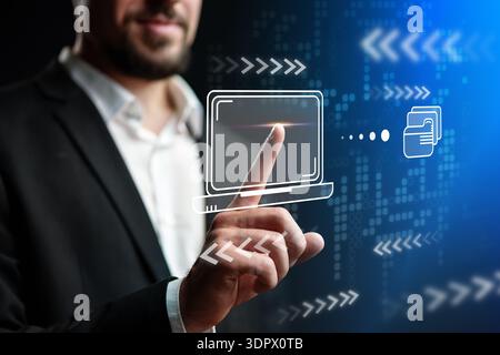 Man interacts with digital interface showing technology and data transfer in a modern setting Stock Photo