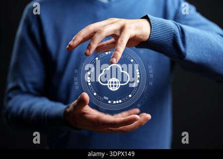 Hands hold a digital cloud symbol showing global connectivity in a dark setting Stock Photo