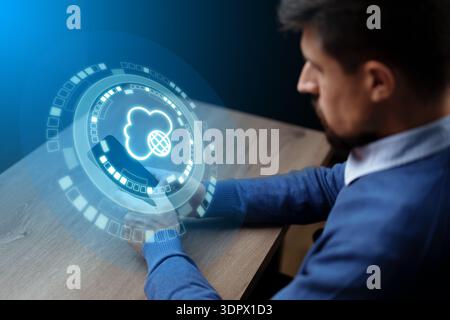 Man interacts with digital cloud interface in office setting during daytime Stock Photo