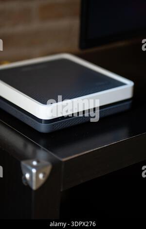 Modern internet router or modem device on a dark table, providing high-speed wireless connectivity and broadband network access for homes and offices Stock Photo