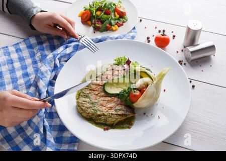 Table Set With Food and Salad During a Meal in a Bright Room With Natural Light Stock Photo