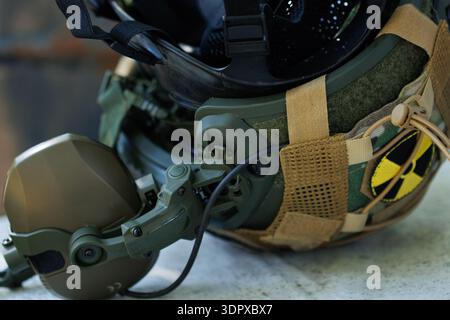 Military style protective helmet equipped with communication headset and gas mask attachment symbolizing hazardous environment operations Stock Photo
