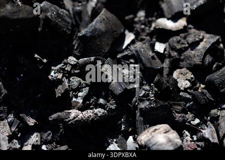 Close-Up Charcoal Pieces Texture Background Description: Detailed macro texture of black charcoal fragments with sharp contrast and rough natural Stock Photo
