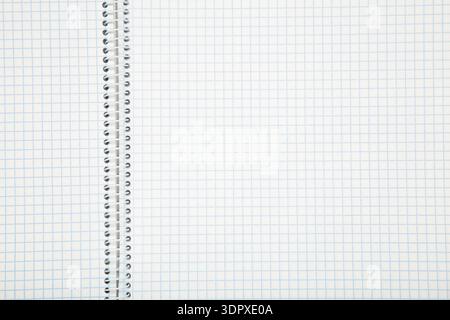Macro shot of a black metal double-wire spiral binding on white notebook. Top view Stock Photo