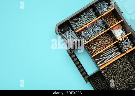Yellow case with small construction objects on blue background. Space for text Stock Photo