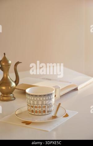 Soft sunlight shines on a white table with coffee cup and an empty planner Stock Photo
