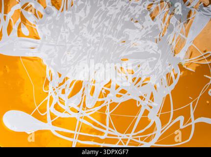 Abstract fluid art painting in acrylic paints,swirling paints, golden yellow and white colors creating Stock Photo