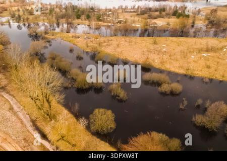 Overflowing rivers flood coastal meadows and trees. Stock Photo