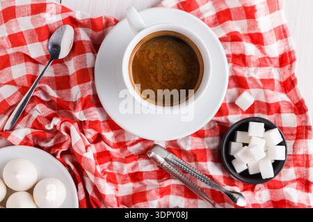 Coffee and Sugar Cubes on a Checkered Tablecloth With Snacks in a Simple Setting Stock Photo