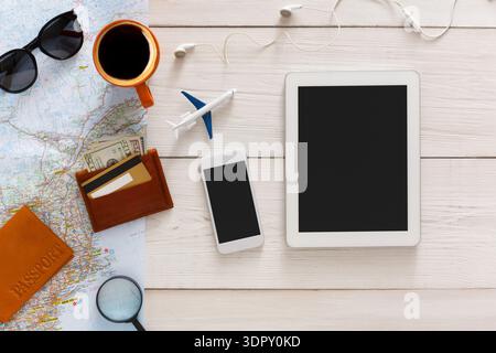 Travel Planning With Maps, Devices, and Essentials on a Wooden Table During the Day Stock Photo