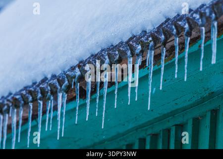 Icicles on the roof of the house. Danger of falling Stock Photo