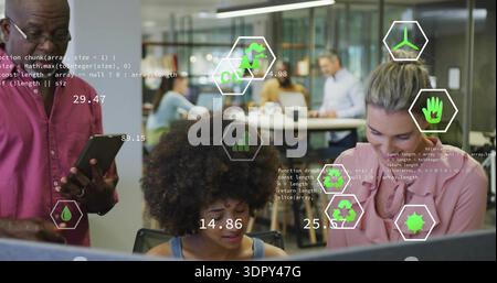 Working curly-haired woman in sleeveless top focusing on monitor in workspace with tablet overlays Stock Photo