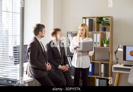 Business team discussing financial strategy with laptop in office meeting Stock Photo