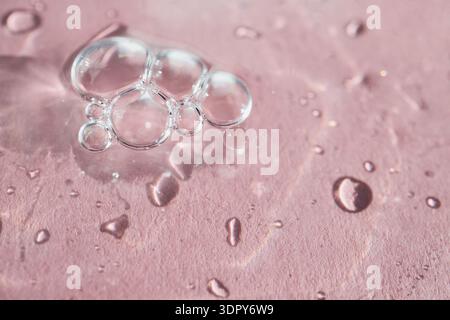 Clear bubbles and water drops creating organic patterns on pink surface Stock Photo