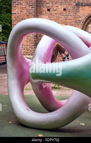 Helsingborg, Sweden - 12 August 2025: View of a swirling, pastel-colored sculpture against the backdrop of an old brick building, blending the modern Stock Photo