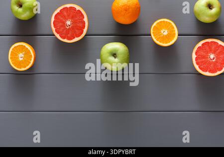 Arrangement of Citrus Fruits and Apples on a Grey Wooden Surface for a Fresh Food Display Stock Photo