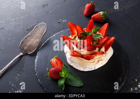 Delicious Dessert Made With Meringue, Cream, and Fresh Strawberries on a Dark Background Stock Photo