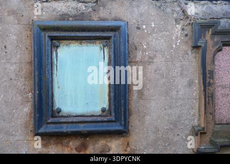 Edinburgh, Scotland - 28 JAN 2025 - An old retro and distressed picture frame or plaque on a historic stone wall with blank contents. Stock Photo