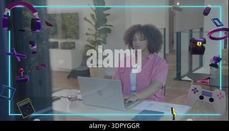 Working woman typing on silver laptop at office, wearing pink shirt, wristwatch, neon gaming icons Stock Photo