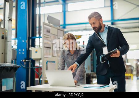 Industrial team analyzing data in high tech manufacturing plant. Stock Photo