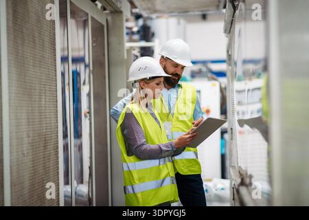 Industrial team analyzing data in high tech manufacturing plant. Stock Photo